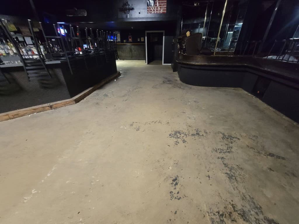 Stained bare concrete floor in a bar before commercial epoxy coating