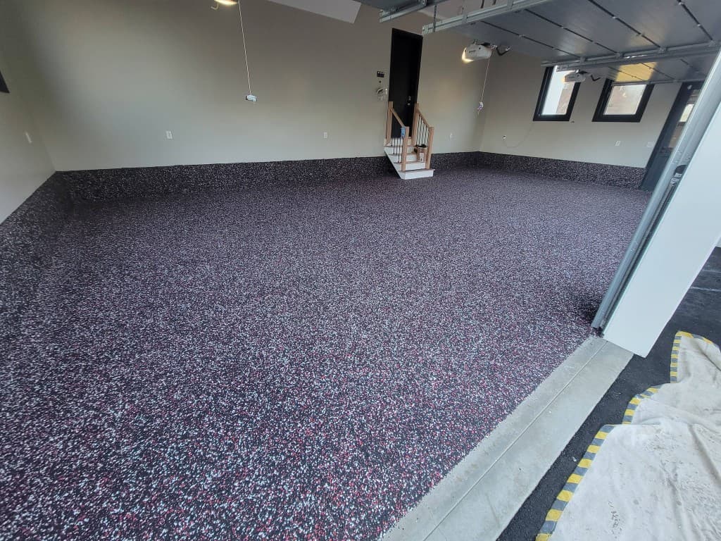 Same garage with full-broadcast dark black, white, and red flake epoxy after installation