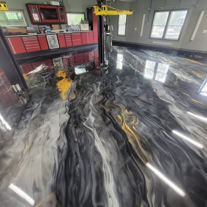 Same car shop with dramatic black, white, and gold metallic swirl epoxy floor after installation